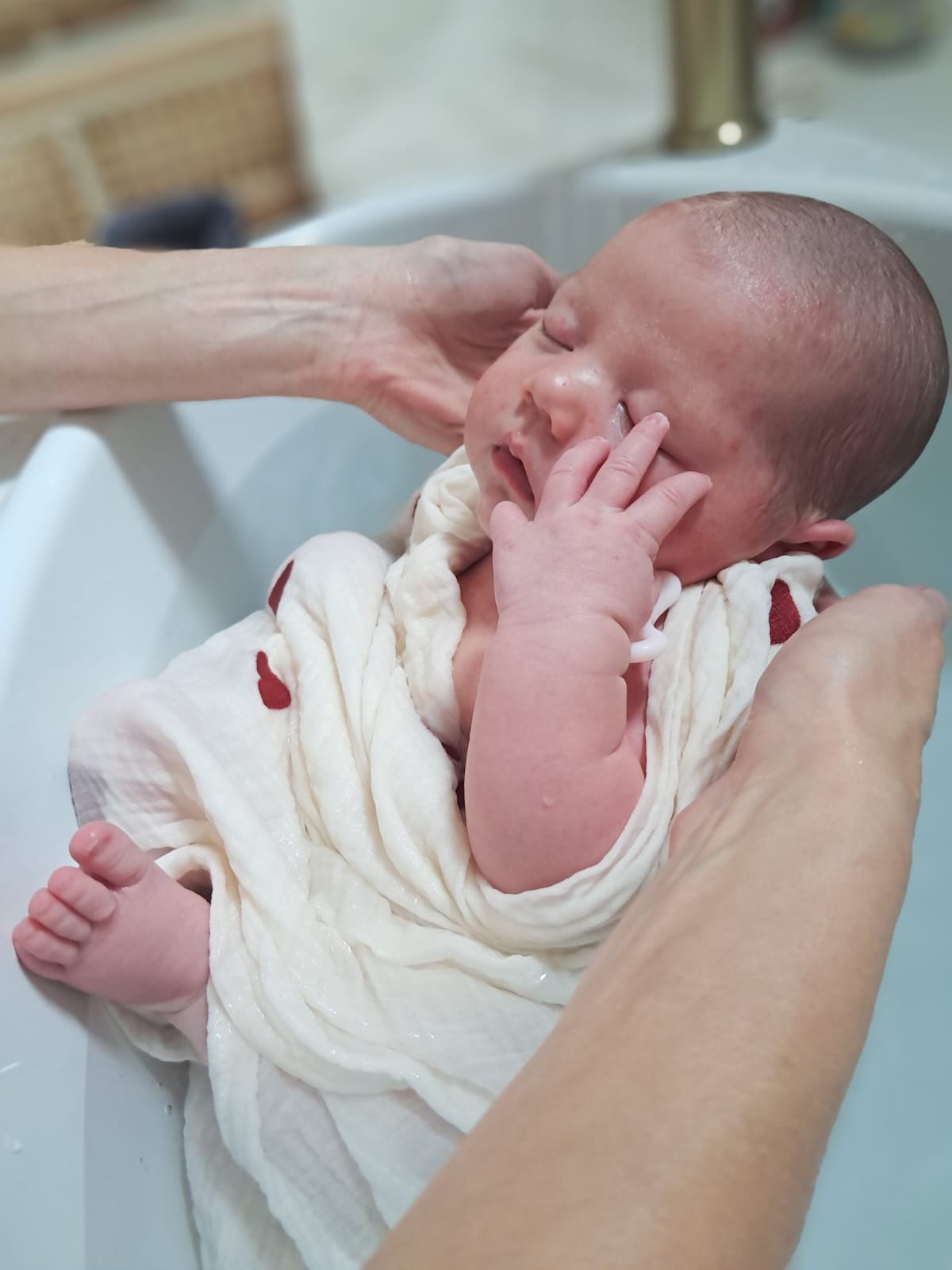 Bébé pendant son bain thérapeutique emmailloté et langé, paisible détente