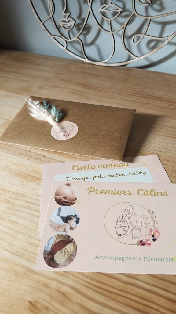 Carte cadeau Premiers câlins pour un massage post-partum, posée avec son enveloppe kraft