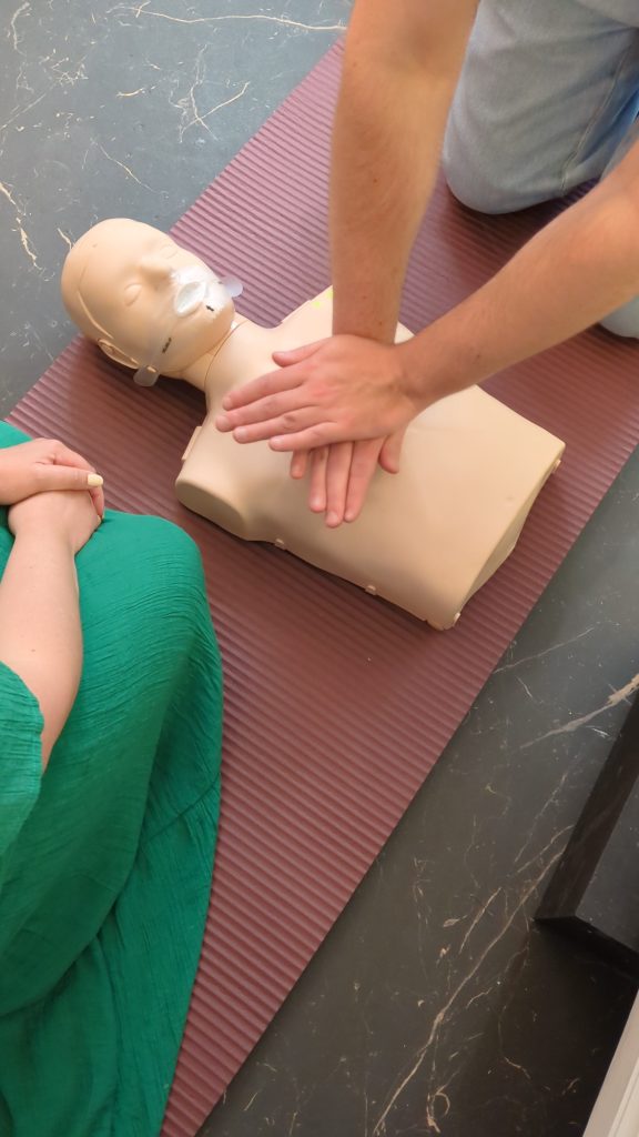 Massage cardiaque sur un mannequin d’entraînement, lors de l’atelier de premiers secours pédiatriques