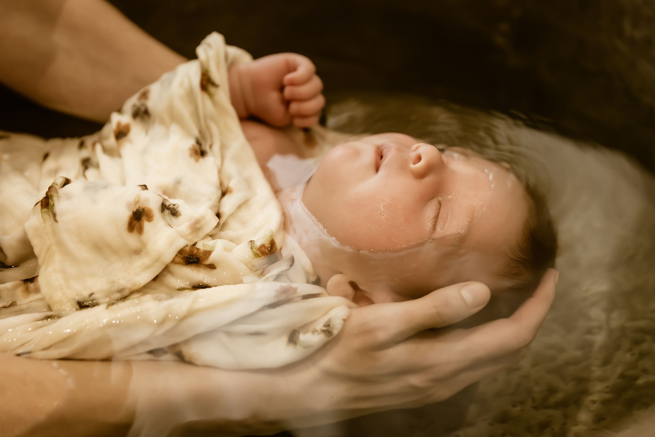 Souvenir photographique d’un bébé enveloppé dans un lange pendant son bain